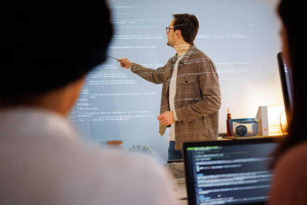 istock Teacher giving computer science lecture to in small home office 1449198662