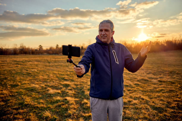 istock Social media influencer creating content. Man shooting video of himself using cellphone. 1449204246
