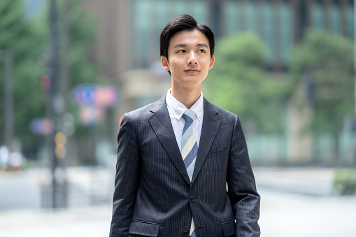 Portrait of young Asian cool-attitude businessman on street