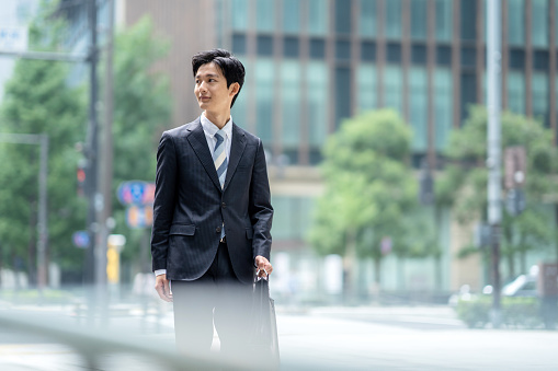 Outdoor Portrait of young Asian Indian businessman wearing business suit and looking at camera.