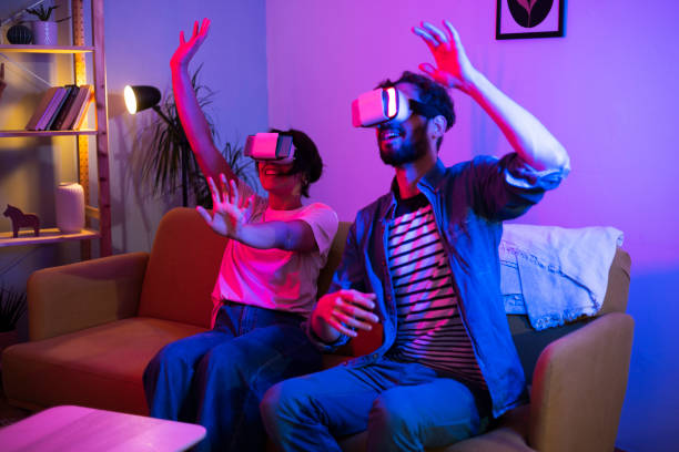 istock Young couple playing VR games and having fun at home 1449207411