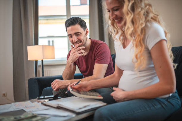 istock Cheerful Young Married Couple Paying Their Debts At Home 1449210897