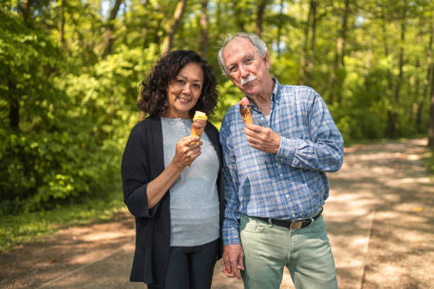 encantadora latina tomando helado con su esposo mayor caucásico - 5949 fotografías e imágenes de stock