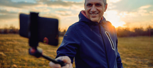 istock Social media influencer creating content. Man shooting video of himself using cellphone. 1449216896