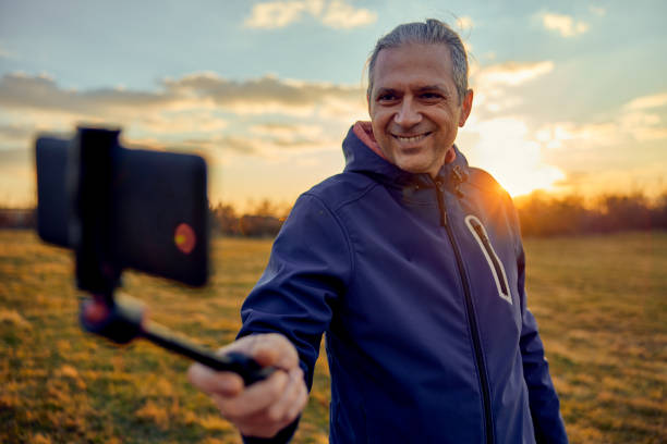 istock Social media influencer creating content. Man shooting video of himself using cellphone. 1449217338