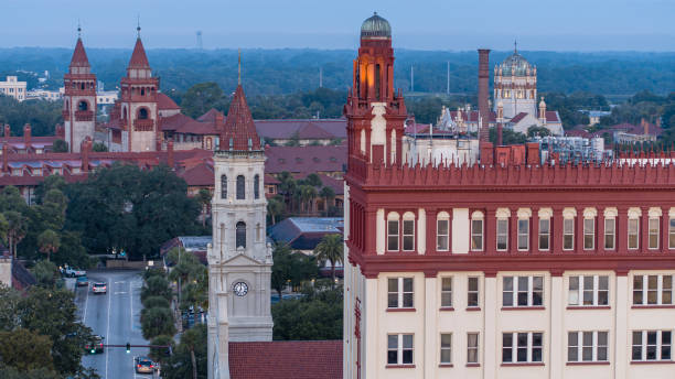 an early morning view of st. augustine's historic downtown, including the cathedral basilica of st. augustine, the hotel with 5 g cell equipment on the roof, flagler college, and city hall. - saint augustine cathedral imagens e fotografias de stock