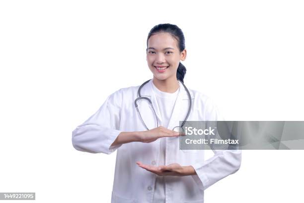 Asian Female Medical Doctor Showing Empty Copy Space On The Open Hands Palm For Text Or Product Isolated On White Background Looking At The Camera Stock Photo - Download Image Now