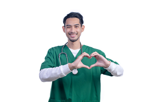 Asian male medical doctor with a stethoscope showing heart symbol by palms, standing and looking at camera isolated on white background,