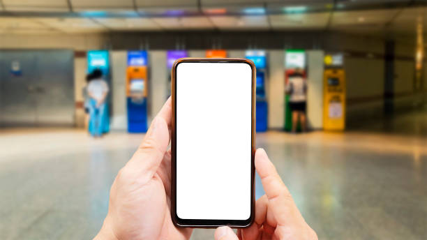 istock Hand holding smartphone, blank screen to put advertising material, picture message, background people are withdrawing money from ATM. 1449222048