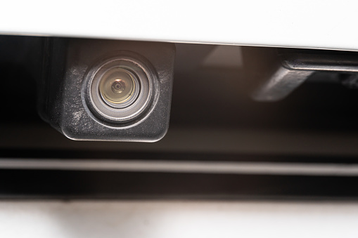 rear view camera close up for parking assistance. Concept of safety car driving while parking process. Assist device equipment in modern cars. Small camera attached to car