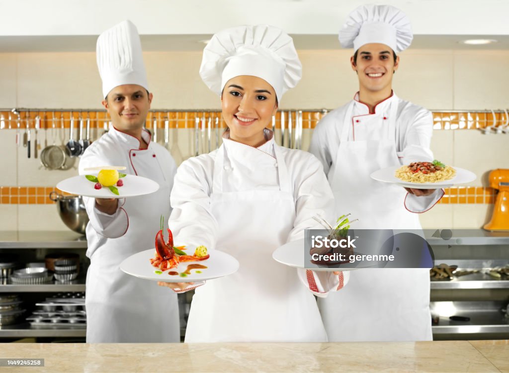 Team spirit In the kitchen Chef trio preparing food in commercial kitchen Lobster - Seafood Stock Photo