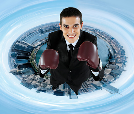 Businessman with boxing gloves ready for a career fight in the city