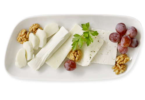 Cheese plate full of delicatessen with clipping path on white background