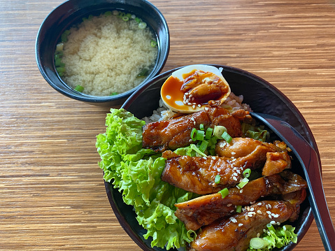 A bowl of teriyaki chicken rice or Chicken Teriyaki Don served with lettuce, egg and miso soup