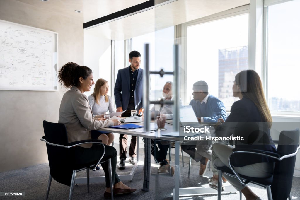 Business man talking to his team in a meeting at the office Successful Latin American business man talking to his team in a meeting at the office Business Meeting Stock Photo