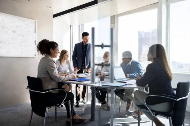 Photo of Business man talking to his team in a meeting at the office