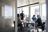 Successful business man talking to a group of people in a meeting a the office