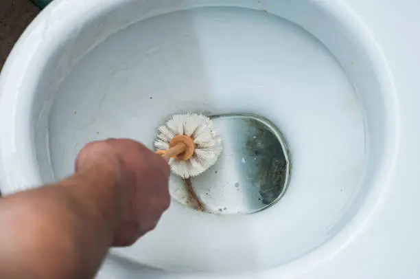 Photo of The result of using different methods of cleaning the toilet bowl in one photo, using chemistry and a mechanical hand wash