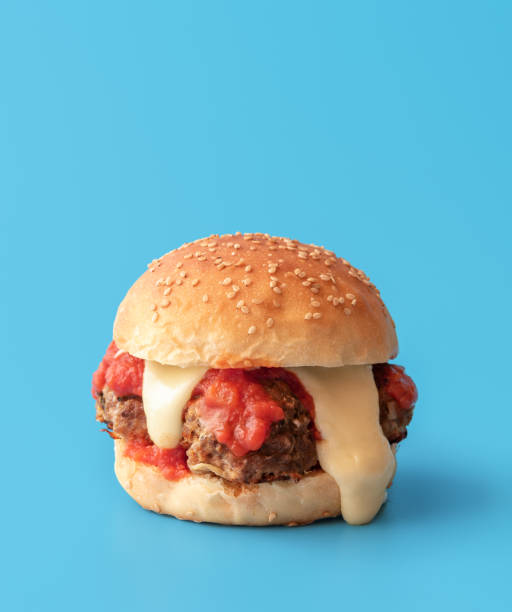 istock Meatballs burger with melted cheese, minimalist on a blue background 1449261998