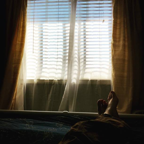 istock Window with feet at the end of bed 1449266240