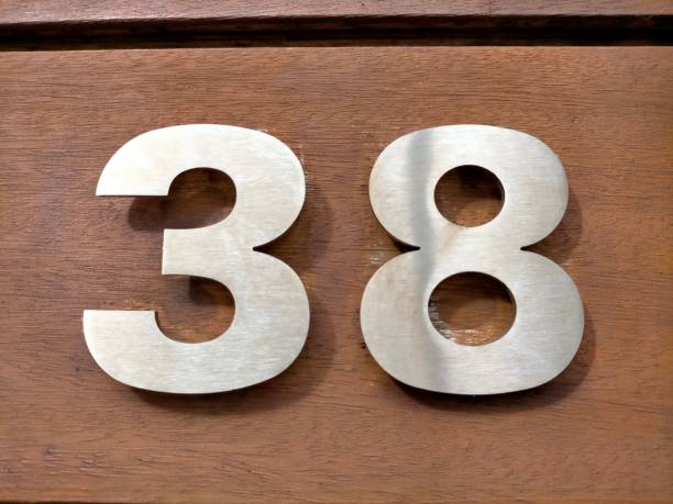 istock Thirty-eight, 38 chrome-colored metal, on a wooden surface. 1449267543