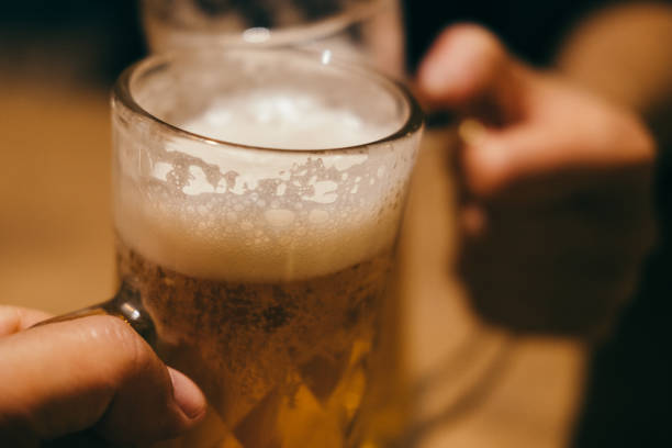 istock Two people toasting with beer mugs 1449269368