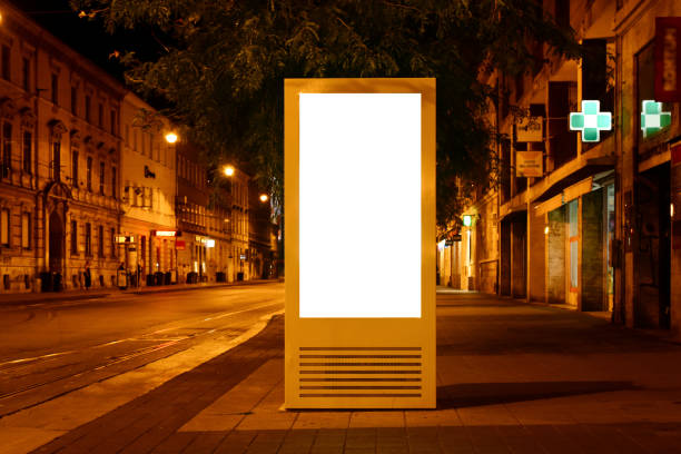 night image of bus stop with illuminated poster ad and billboard lightbox. mock-up base. night image of bus stop with illuminated poster ad and billboard lightbox. glass and steel bus shelter. mock-up base. empty white exterior ad panel. diminishing street perspective background. bus shelter stock pictures, royalty-free photos & images