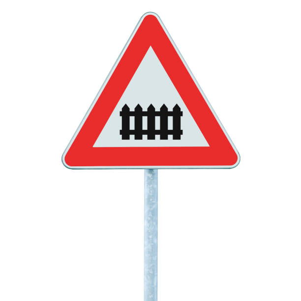 istock Railroad level crossing with railway barrier or gate ahead road sign, isolated grey pole post, roadside traffic triangle signage, large detailed vertical closeup 1449278066