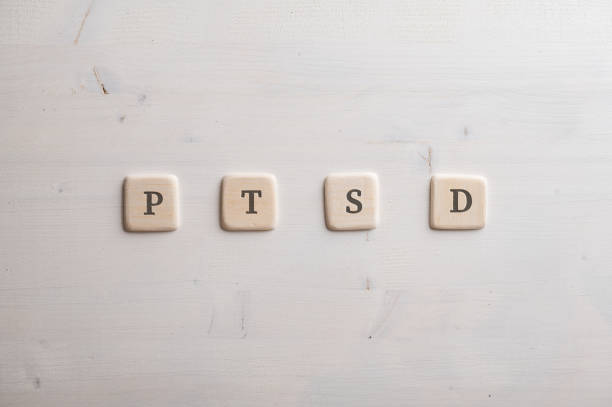 PTSD spelled over four wooden cut squares placed over wooden background.