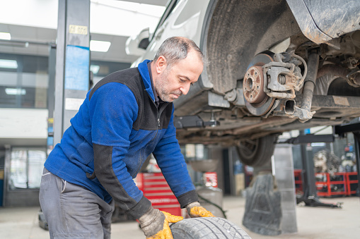 The Auto Mechanic Changing A Wheel Of A Car İn Car Service