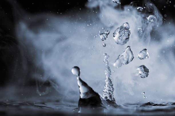 istock Boiling water splash with steam on black background closeup 1449282579