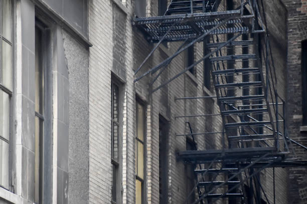 FDNY fire trucks responding to an apartment fire on Bedford Avenue in Brooklyn New York City with ladders into broken windows.