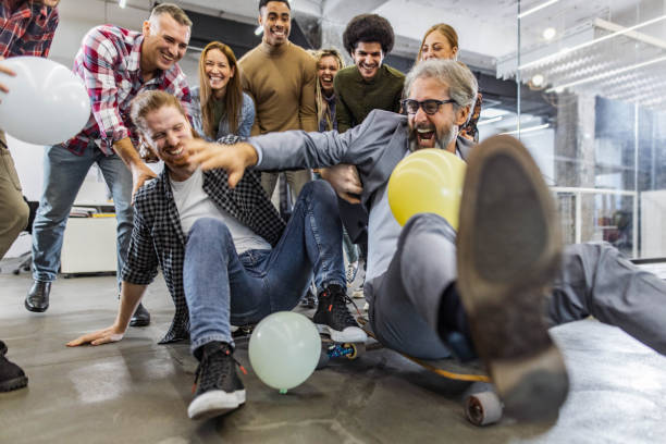 istock Cheerful freelancers having fun during skateboard competition at casual office. 1449285709