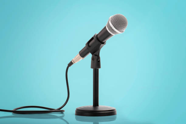 istock Retro microphone on wooden table with blue wall background 1449285989