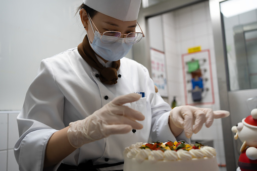 Female pastry chef decorating cake