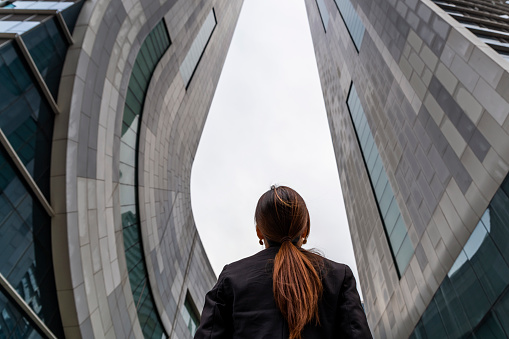 Back view of business woman looking at the city buildings