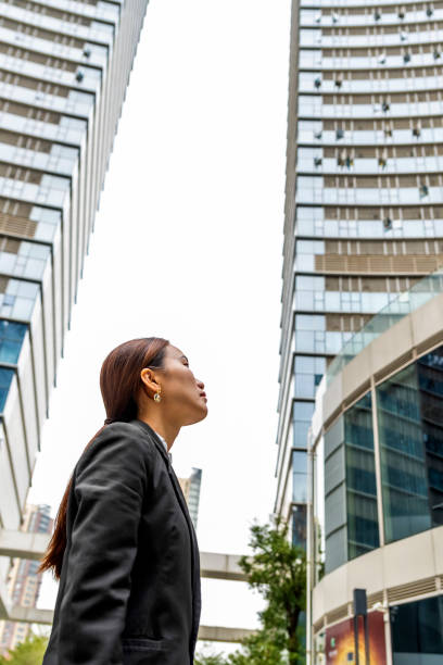 istock Young Asian woman outdoors looking toward sky 1449292187
