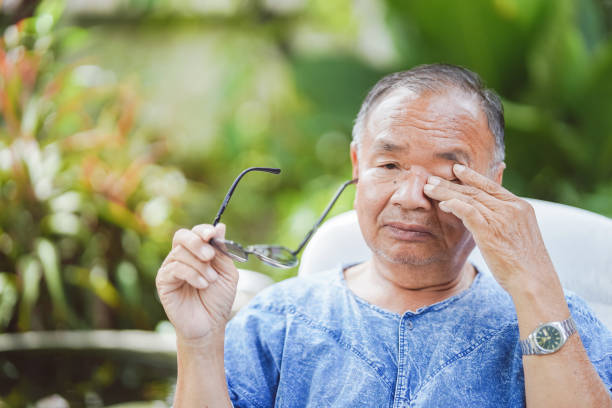 istock Elderly man rubbing his eyes while holding glasses due to overuse of the eyes, causing itching and irritation. 1449292195
