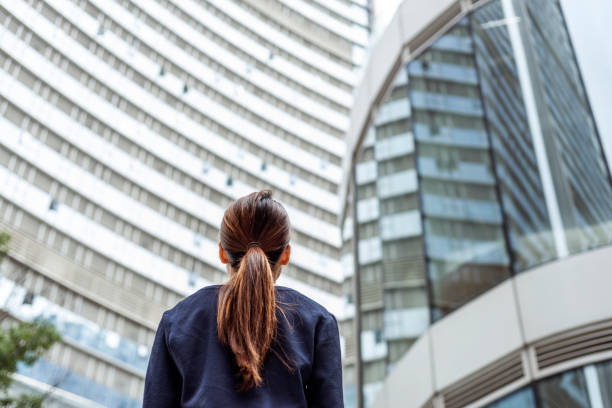 istock Businesswoman thinking on the street while looking up. 1449292232