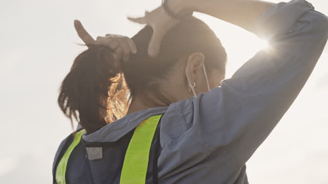 Slow motion of female engineer with hair tied up getting ready for work,Close-up