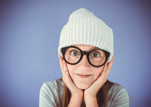 Full of happiness. warm clothes for cold season. knitted accessory. small girl winter hat. kid fashion. trendy girl look like hipster. surprised child pink background. autumn style. happy childhood.
