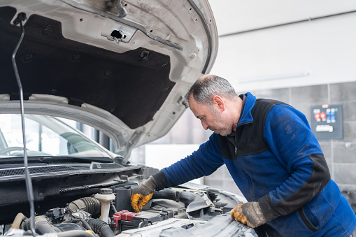 The Auto Mechanic Repairing A Car Engine