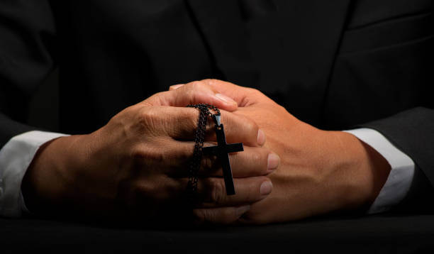 istock Christian man praying with faith on black background. 1449303328