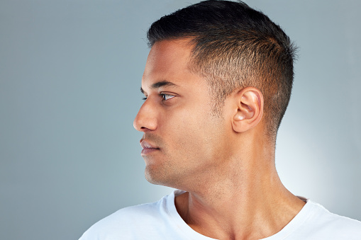 Face, beauty and masculine with a man model profile in studio on a gray background for skincare or wellness. Luxury, health and cosmetics with a handsome young male posing to promote health skin