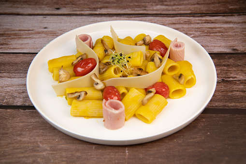 Recipe for Rigatoni Pasta with Chiatsu Squash Cream, Ham, Tomato, Mushrooms and Parmesan. High quality photo
