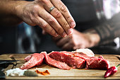 Preparing fresh beef slices with spices ready to cook