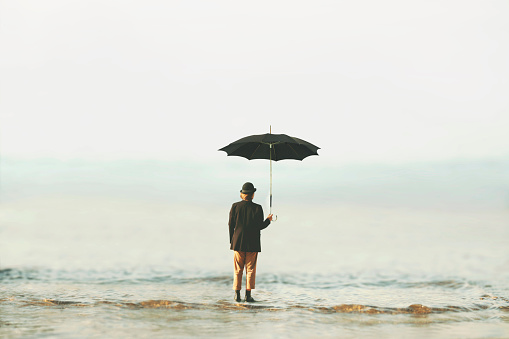 surreal woman with bowler hat and umbrella looks towards infinity, business and freedom concept