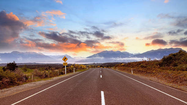 a vista da viagem rodoviária da viagem com vista para a montanha da cena do outono e nebulosa pela manhã com a cena do céu do nascer do sol no parque nacional fiordland - sunrise new zealand mountain range mountain - fotografias e filmes do acervo