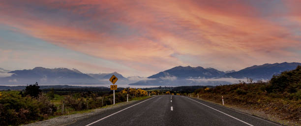 the road trip view of  travel with mountain view of autumn scene and  foggy in the morning with sunrise sky scene at fiordland national park - new zealand forest landscape mountain imagens e fotografias de stock