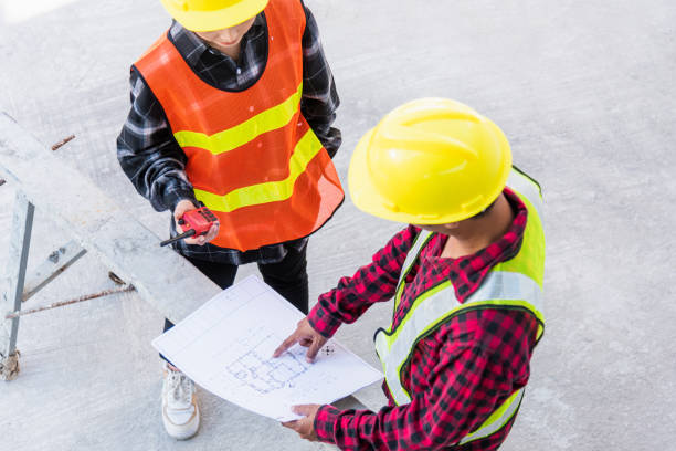 istock Architect and client discussing help create plan with blueprint of the building at construction site floor. Asian engineer foreman worker man and woman meeting and planning construction work, top view 1449315172
